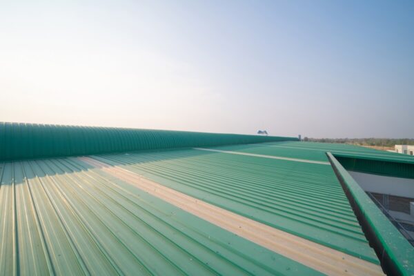 Zielony dach pokryty blachą trapezową w słoneczny dzień.