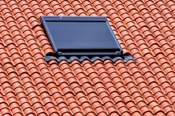 Na zdjęciu widać dach z dachówki ceramicznej z zamontowanym oknem dachowym.